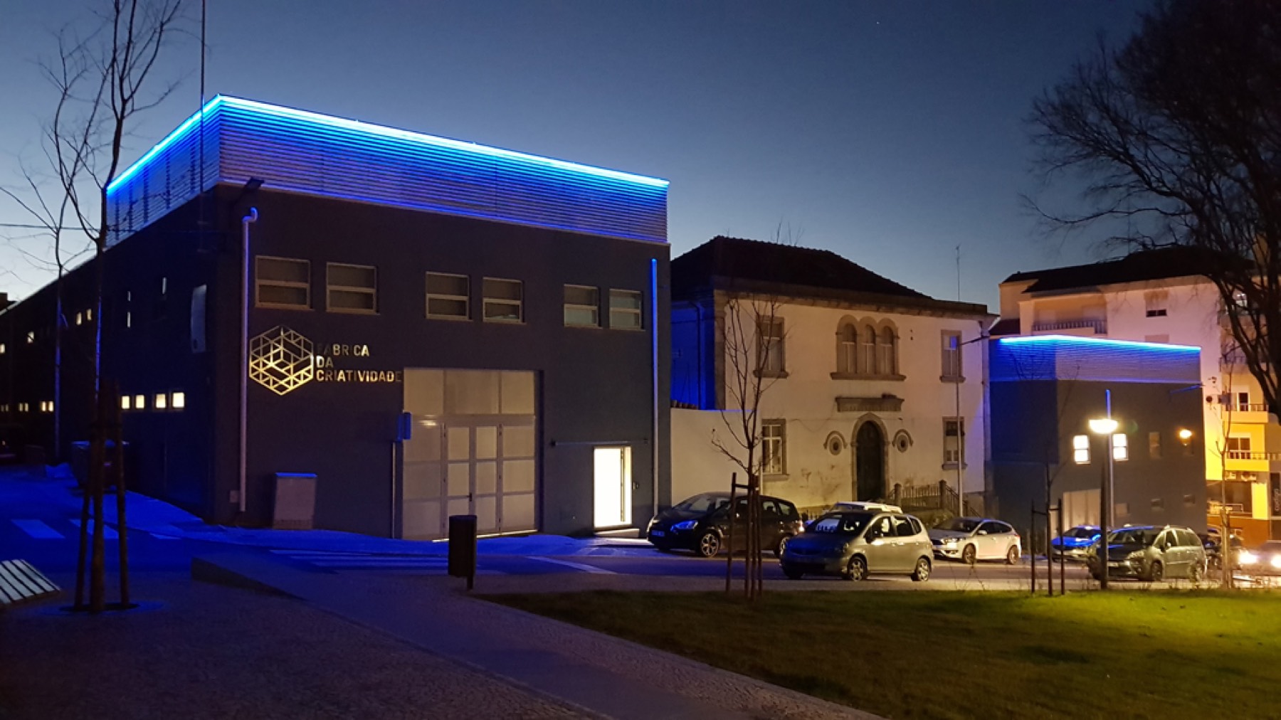 A Fábrica da Criatividade à noite, em Castelo Branco, com a faixa de luz azul na cobertura.